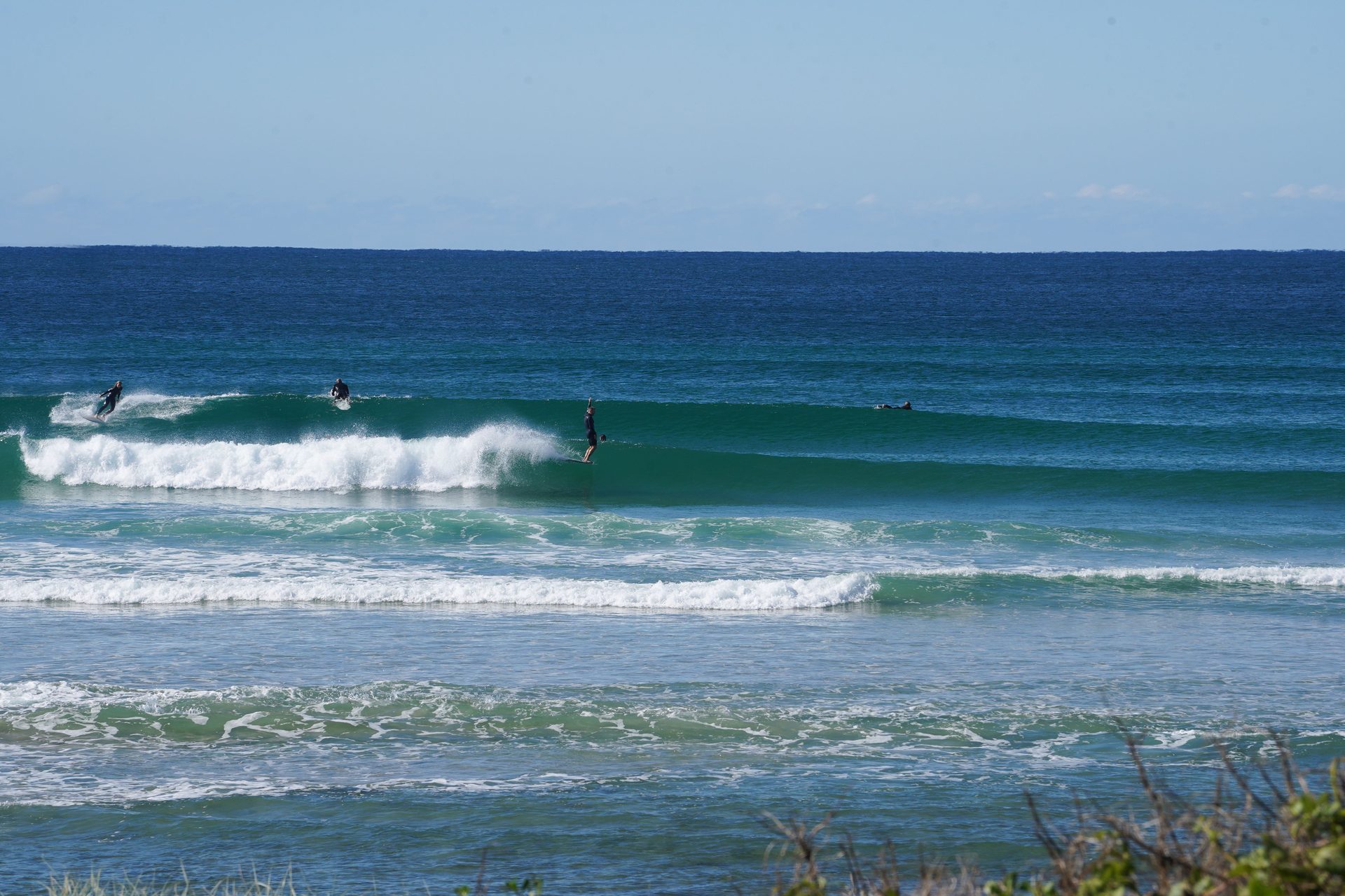 Surfers sharing waves in a green lineup